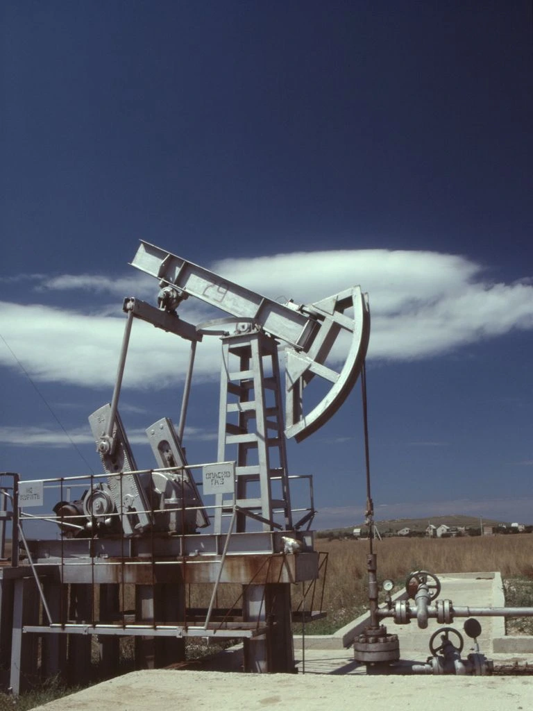 Tethered drone monitoring a remote oilfield site at dawn